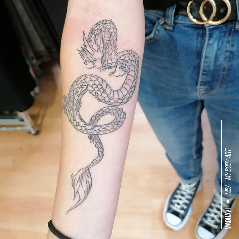 tattoo femme dragon Haku sur le bras, tatouage illustratif tendance du Voyage de Chihiro, réalisé par Madhavi, tatoueuse à MBA - My Body Art Grenoble