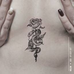 tattoo femme underboobs modèle serpent et fleur rose avec feuilles sexy réalisé par Melow tatoueuse résidente à MBA - My Body Art Lyon